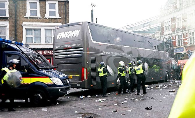 Police get into action as bottles are thrown at the Manchester United team bus before the match