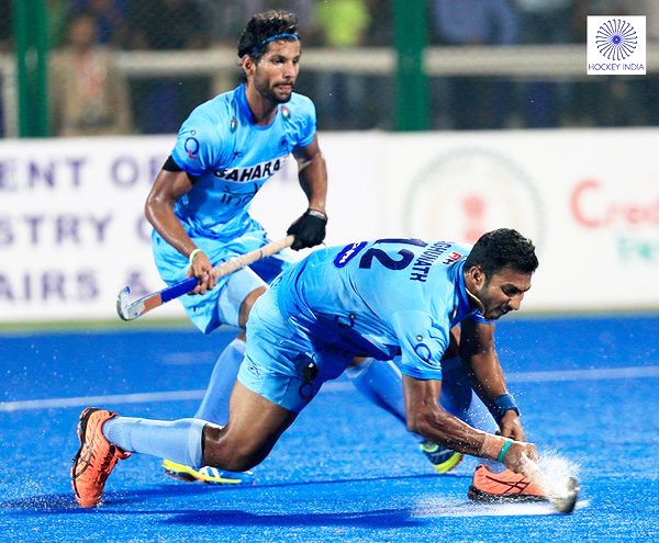 India's VR Raghunath plays a drag flick as teammate Rupinder Pal Singh watches