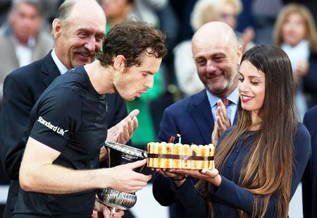 Andy Murray blows out candle on his birthday cake after winning the match against Novak Djokovic to win the Italian Open on Sunday