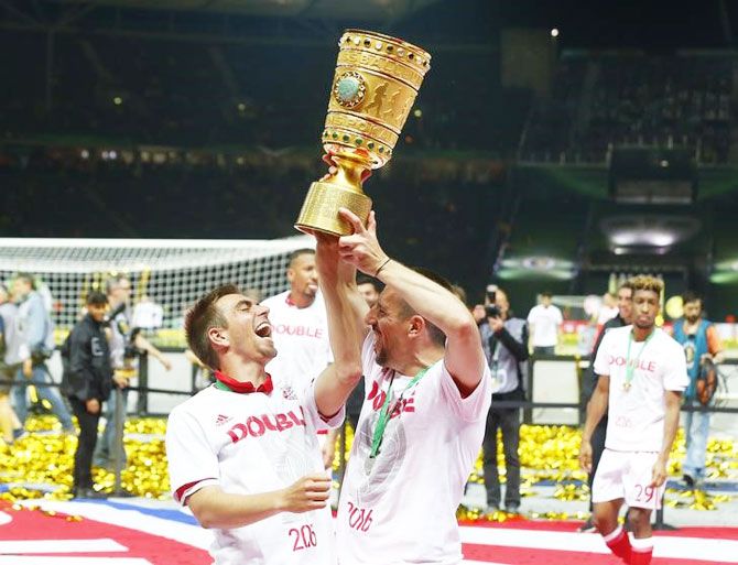 Bayern Munich players Franck Ribery and Philipp Lahm celebrate with the trophy after winning the German Cup at Olympiastadion, Berlin, on Saturday