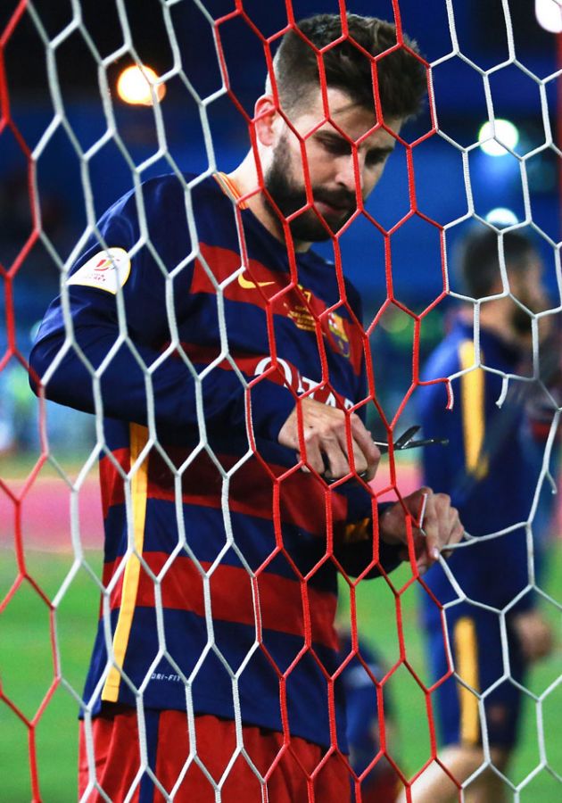 FC Barcelona's Gerard Pique cuts a piece of the goal's net after winning the final