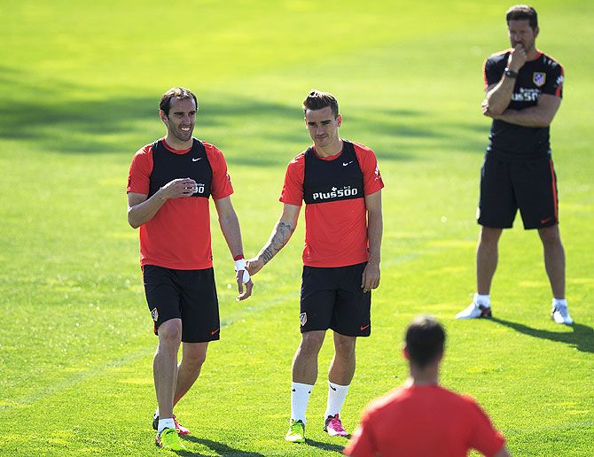 Head coach Diego Pablo Simeone (right) supervises Atletico de Madrid players Diego Godin (left) and Antoine Griezmann (2nd from left) during the training session in Majadahonda, Spain