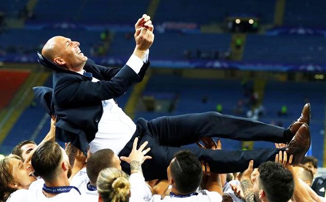 Real Madrid coach Zinedine Zidane is thrown in the air as they celebrate winning the UEFA Champions League final at San Siro on Saturday