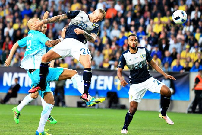 Sweden's John Guidetti heads a ball away from a Slovenian player as teamate Isaac Kiese Thelin watch duirng their international friendly in Malmo, on Monday
