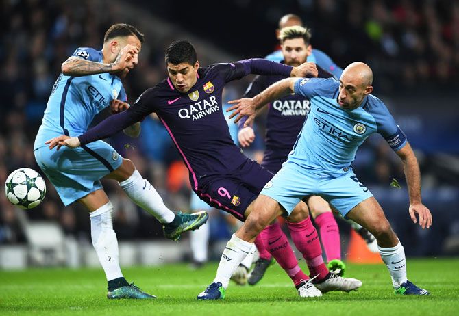 Barcelona's Luis Suarez (centre) is tackled by Manchester City's Nicolas Otamendi (Left) and Pablo Zabaleta