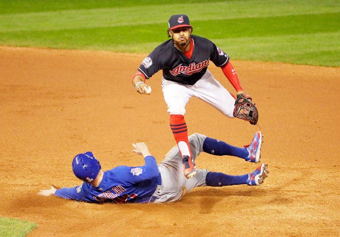 Francisco Lindor #12 of the Cleveland Indians jumps over Chris Coghlan #8 of the Chicago Cubs as Coghlan is out at second base