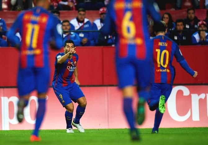 FC Barcelona's Luis Suarez celebrates with teammate Lionel Messi after scoring  against Sevilla during their La Liga match at Ramon Sanchez Pizjuan Stadium in Seville on Sunday