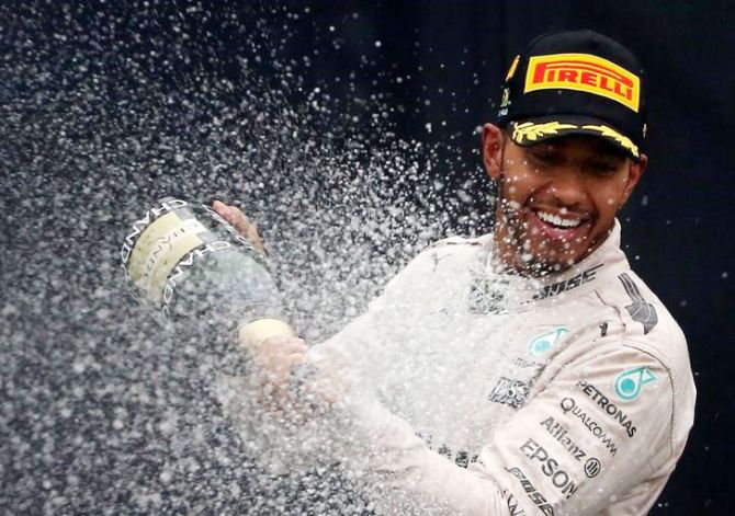 Mercedes' British driver Lewis Hamilton sprays champagne during the victory ceremony after winning the Brazilian F1 GP race at Interlagos in Sao Paulo on Sunday