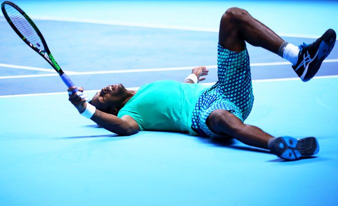 Gael Monfils lies on the floor after sliding for a return during his men's singles match against Dominic Thiem 