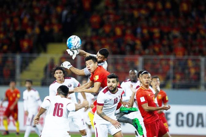 Mei Fang of China and Saad Al Sheeb, Luiz Mairton Junior of Qatar vie for possession during their World Cup 2018 QualifierIN Kunming, China, on Tuesday