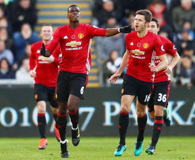 Manchester United's Paul Pogba celebrates scoring his side's first goal with Michael Carrick during their Premier League match against Swansea City at Liberty Stadium in Swansea, Wales, on November 6, 2016