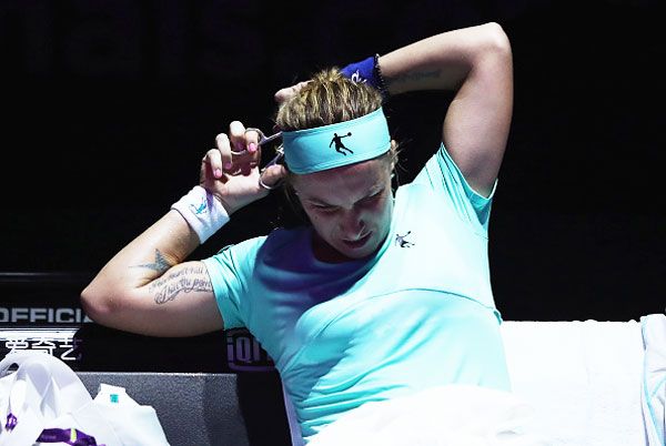 Svetlana Kuznetsova cuts her hair in her singles match against Agnieszka Radwanska during the WTA Finals at Singapore Sports Hub on Monday