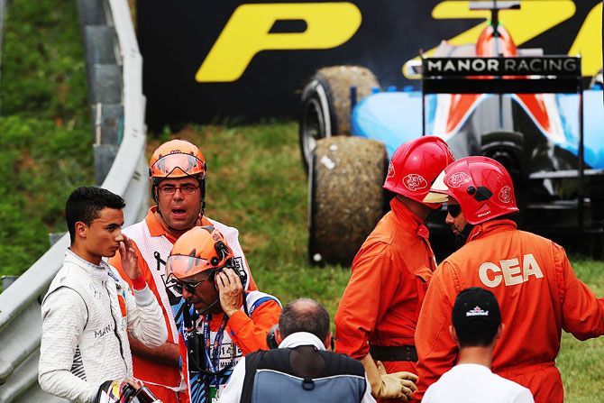 Manor Racing's German driver Pascal Wehrlein (left) stops his car and retires from the race