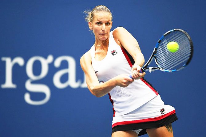 Karolina Pliskova returns a shot while playing against Angelique Kerber
