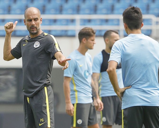 Manchester City's manager Pep Guardiola gestures during the pre-game training