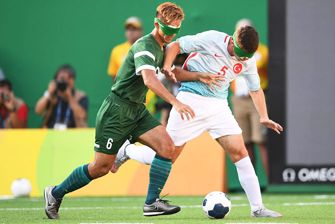 Tiago of Brazil (left) competes for the ball with Recep Aydeniz of Turkey (right) in the men's football 5-a-side on Sunday, September 11