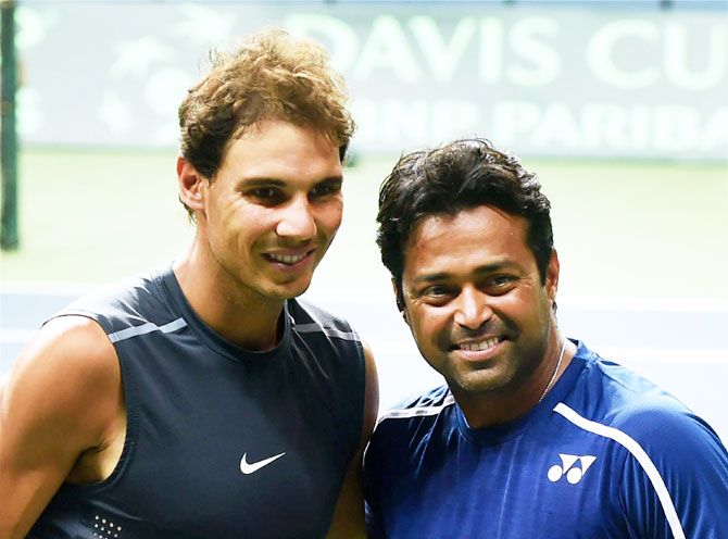Spain's Rafael Nadal and India's Leander Paes pose for photographs after a practice session in New Delhi on Tuesday