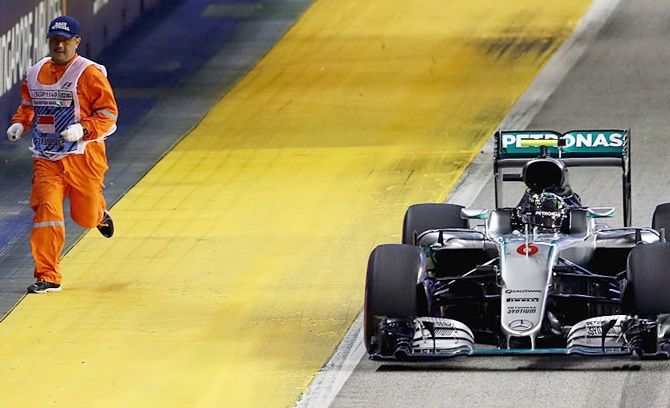Nico Rosberg of Germany driving the Mercedes past a marshal on track during the Formula One Grand Prix of Singapore