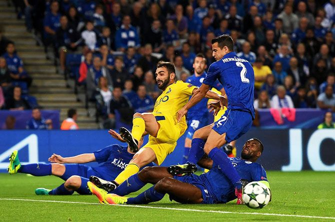 Adrian Lopez of FC Porto is challenged by Luis Hernandez (20) and Wes Morgan of Leicester City