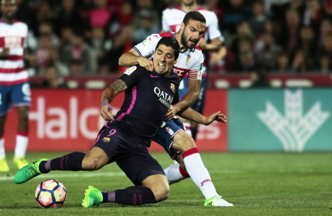 Barcelona's Luis Suarez (left) and Granada's David Lomban vie for possession