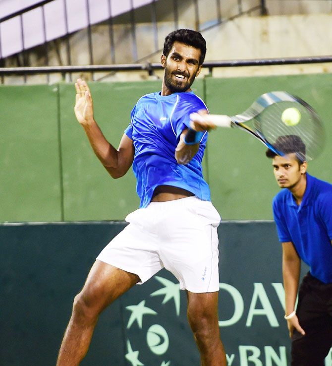 India's Prajnesh Gunneswaran plays a return during his match against Sanjar FAYZIEV of Uzbekistan during the Second singles match of the Asia Oceania Group 1 tie at KSLTA in Bengaluru on Friday