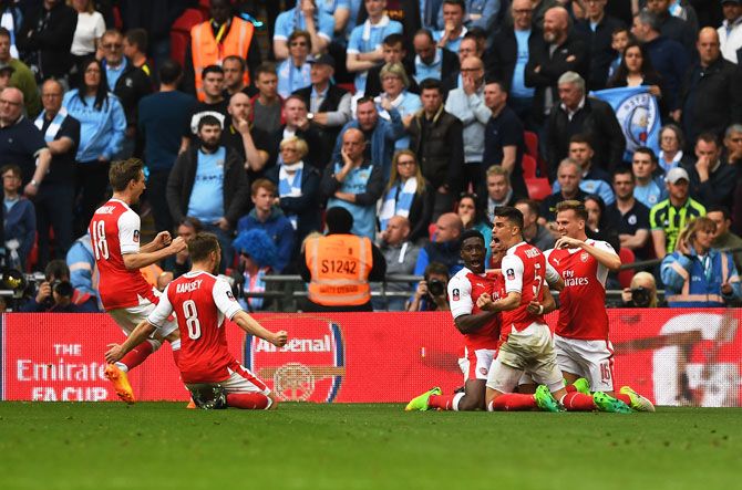 Arsenal's players celebrate with Alexis Sanchez after scoring the second goal against Manchester City during the Emirates FA Cup Semi-Final at Wembley Stadium in London, on Sunday