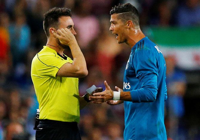 Real Madrid’s Cristiano Ronaldo speaks with referee Ricardo de Burgos Bengoetxea after being shown a red card after receiving a second yellow card for simulation during the Spanish Super Cup first leg match against FC Barcelona on Sunday