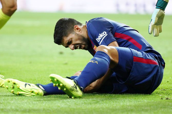 Barcelona's Luis Suarez winces in pain during the Spanish Super Cup 2nd leg match against Real Madrid on Wednesday. He is likely to be out of action for four weeks