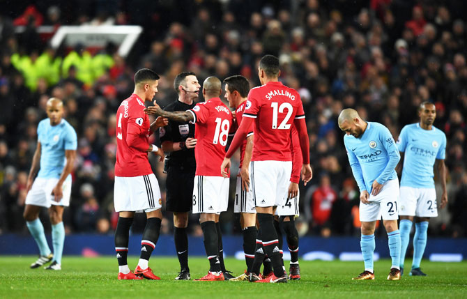 Manchester United's Marcos Rojo, Ashley Young; Ander Herrera and Chris Smalling argue with referee, Michael Oliver during their English Premier League match at Old Trafford in Manchester on Sunday