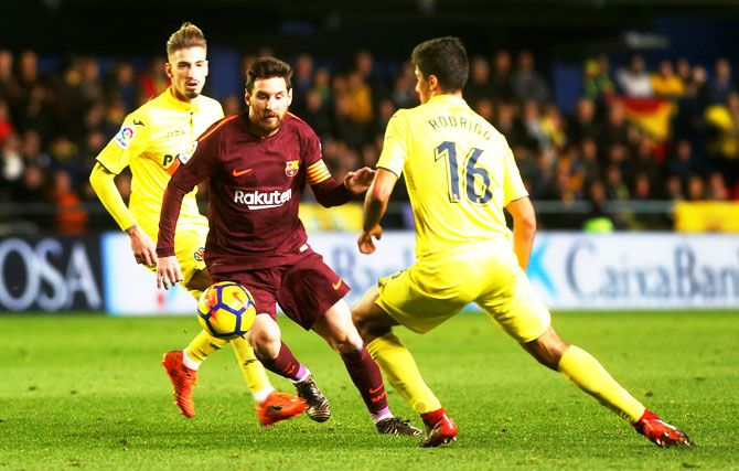 Villarreal's Rodrigo challenges Barcelona’s Lionel Messi during their La Liga match at the Estadio de la Ceramica, in Villarreal on Sunday