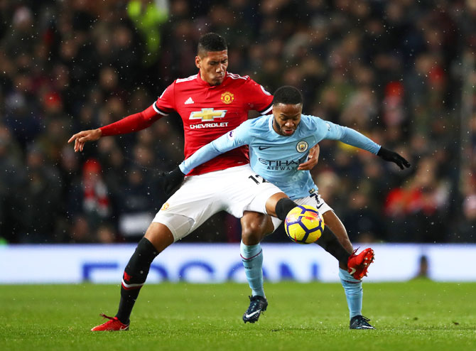 Manchester United's Chris Smalling holds off Manchester City's Raheem Sterling