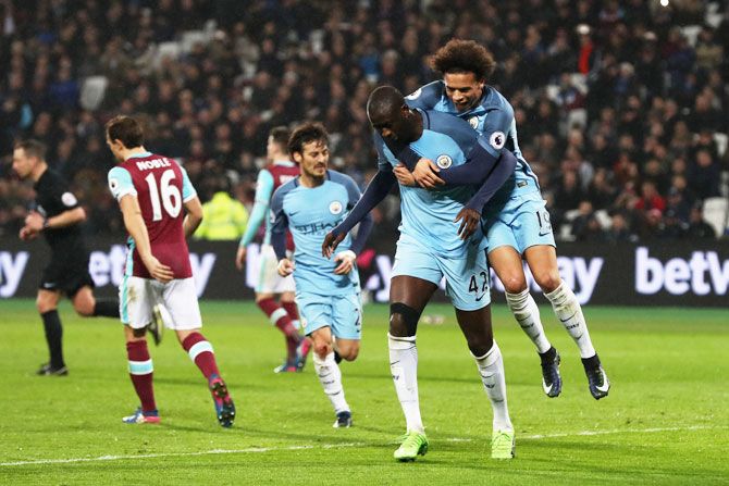 Manchester City'S Yaya Toure celebrates scoring his team's fourth goal with teammate Leroy Sane during their Premier League match against West Ham United at London Stadium in Stratford on Wednesday