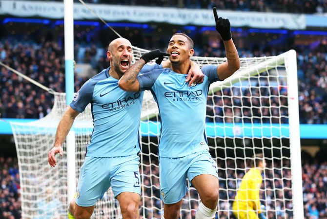 Manchester City's Gabriel Jesus (right) celebrates with teammate Pablo Zabaleta after scoring his side's second goal during the Premier League match against Swansea City at Etihad Stadium in Manchester on Sunday