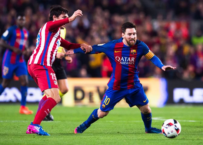 Lionel Messi and Stefan Savic battle for possession 