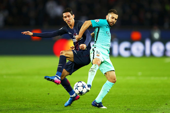Barcelona's Jordi Alba battles for the ball with Paris Saint-Germain's Angel Di Maria