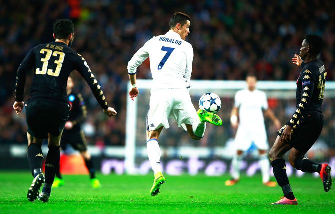 Real Madrid's Cristiano Ronaldo flicks the ball as Raul Albiol (33) and Amadou Diawara of Napoli (42) look on 