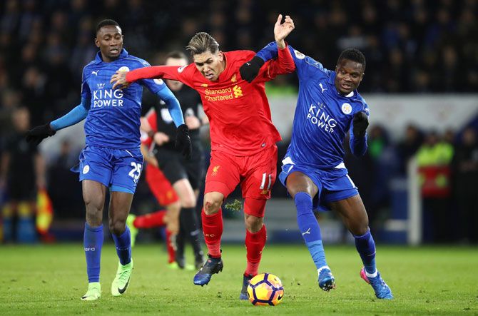 Liverpool's Roberto Firmino  holds off Leicester City's Daniel Amartey (right) and Wilfred Ndidi as they vie for possession