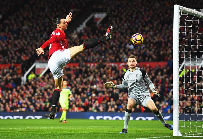 Manchester United's Zlatan Ibrahimovic stretches for the ball as Liverpool 'keeper Simon Mignolet looks on 