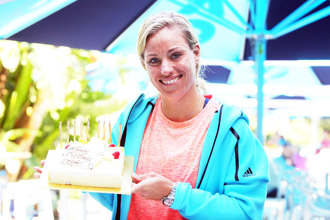 World No 1 Germany's Angelique Kerber poses with a birthday cake which was presented to her by Australian Open Tournament Director Craig Tiley during day three of the 2017 Australian Open on Wednesday