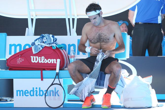 Roger Federer changes his shirt during his second round match against Noah Rubin