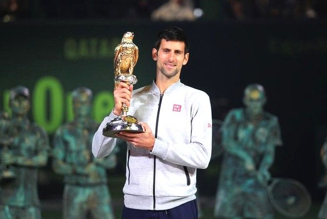 Novak Djokovic holds the trophy aloft after beating Andy Murray to win the Qatar Open in Doha on Saturday