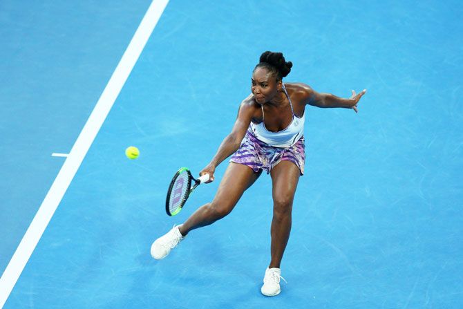 Venus Williams plays a backhand return against Serena Williams