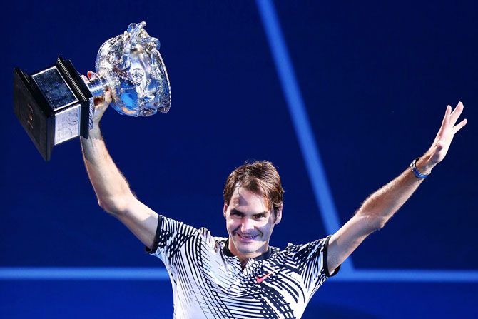 Switzerland's Roger Federer poses with the Norman Brookes Challenge Cup after winning the 2017 Australian Open final against Spain's Rafael Nadal at Melbourne Park on Sunday