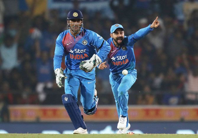 MS Dhoni and Virat Kohli celebrate the fall of an England wicket