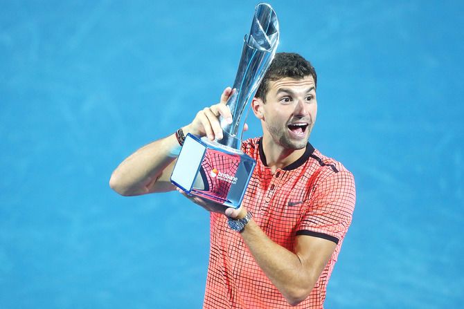 Bulgaria's Grigor Dimitrov holds the Roy Emerson trophy after defeating Japan's Kei Nishikori to win the men's final of the Brisbane international at Pat Rafter Arena in Brisbane, on Sunday