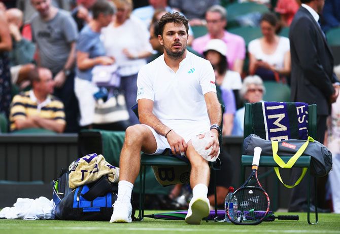Switzerland's Stan Wawrinka puts an ice pack on his knee during his Wimbledon first round match against Russia's Daniil Medvedev at the All England Lawn Tennis and Croquet Club in London on Monday