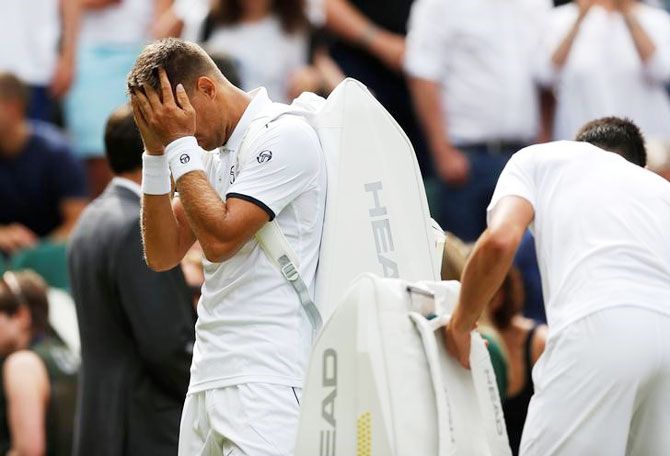 Slovakia’s Martin Klizan reacts as he retires from his first round match against Serbia’s Novak Djokovic after sustaining an injury on Tuesday