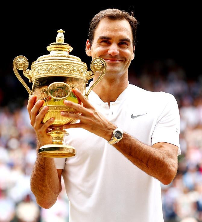 Roger Federer poses with the trophy after winning his 8th Wimbledon title on Sunday