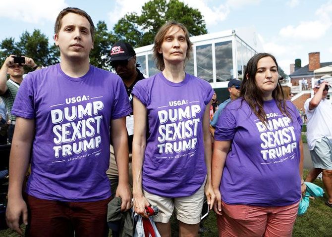Protesters wearing anti-Trump shirts stand in front of US President Donald Trump's personal enclosure at the US Women's Open golf tournament at Trump National Golf Club in Bedminster, New Jersey, USA on Sunday 