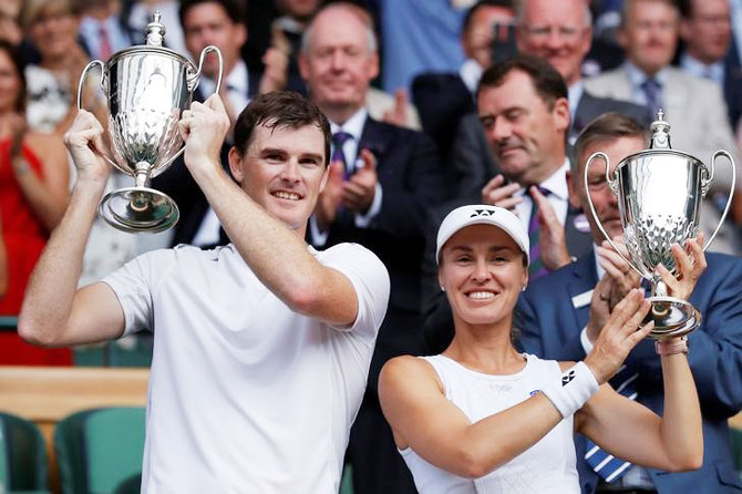 Great Britain’s Jamie Murray and Switzerland’s Martina Hingis pose as they celebrate with their trophies after winning the Wimbledon mixed doubles final against Finland’s Henri Kontinen and Great Britain’s Heather Watson on Sunday